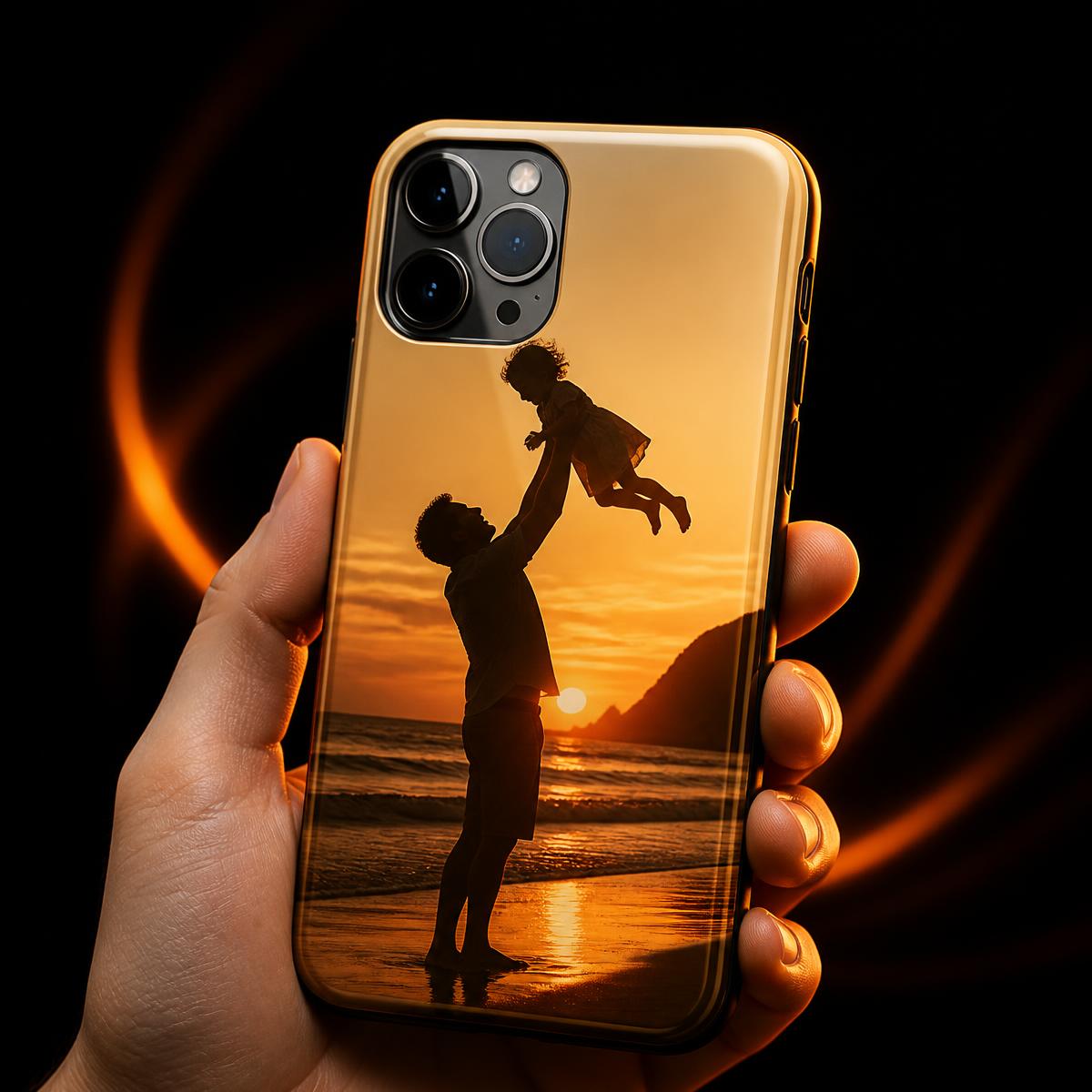 Hand holding a phone case printed with a father lifting his child at sunset